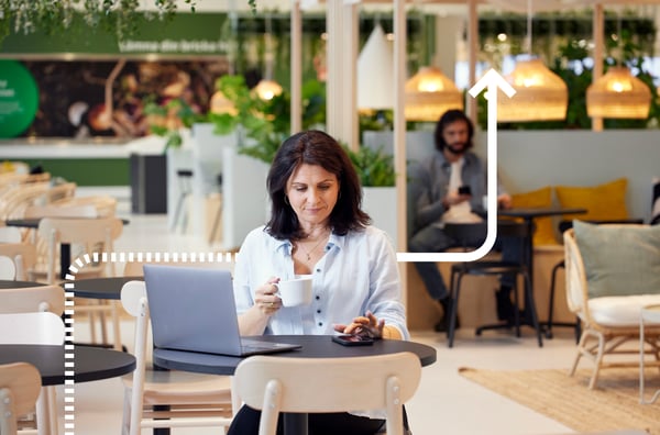 Kobieta siedząca w restauracji z laptopem i smartfonem