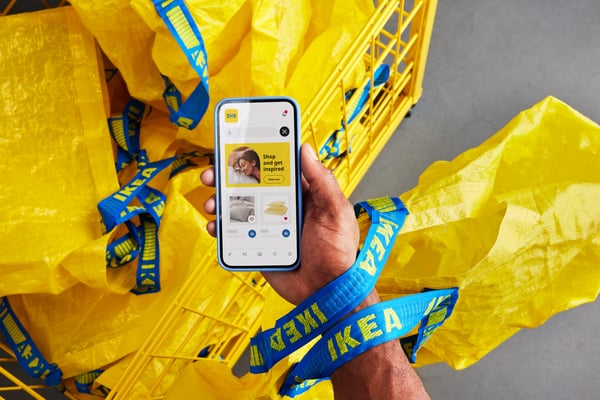 A person holding a phone with yellow bag