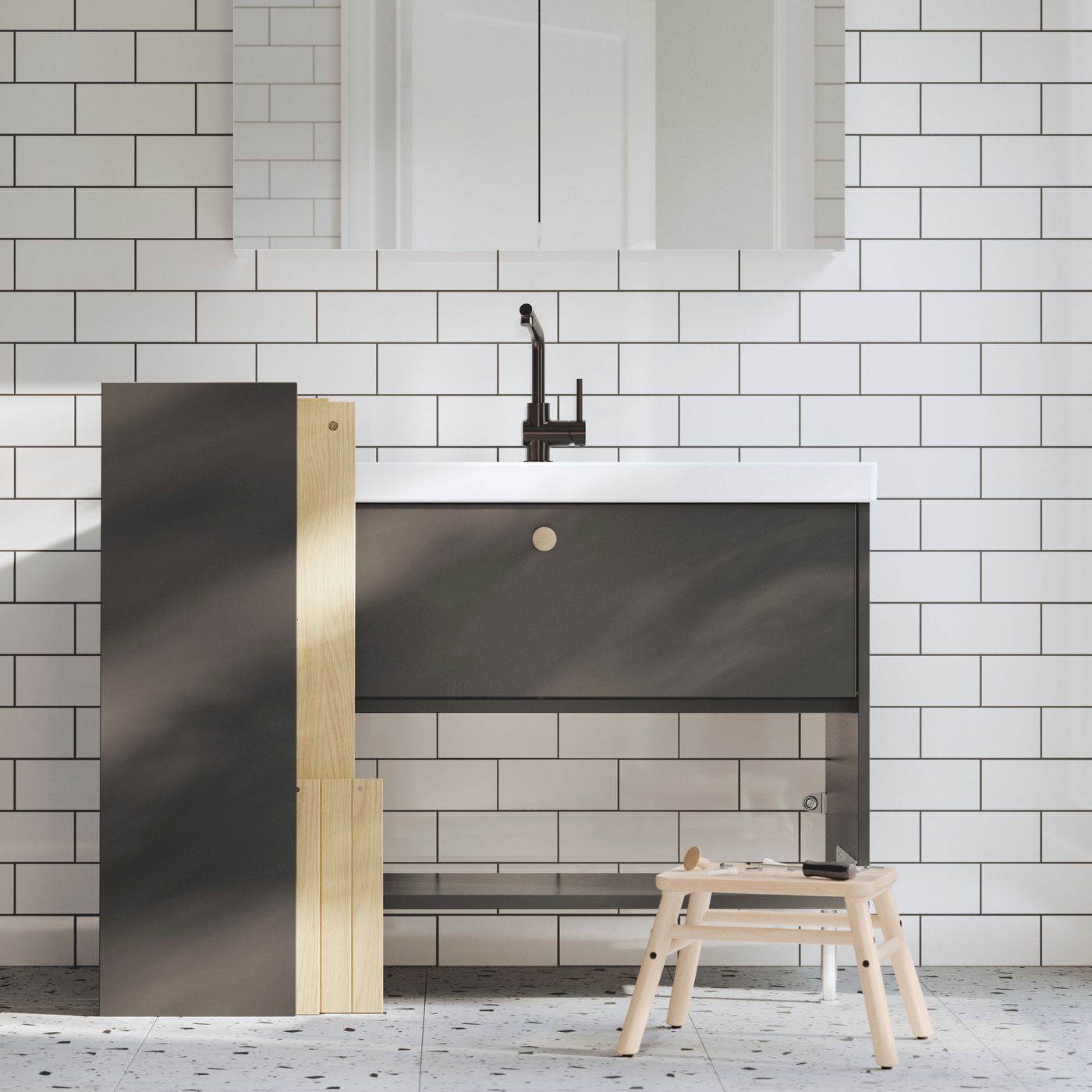 Un bany amb rajoles blanques i un moble de lavabo HAVBÄCK gris.