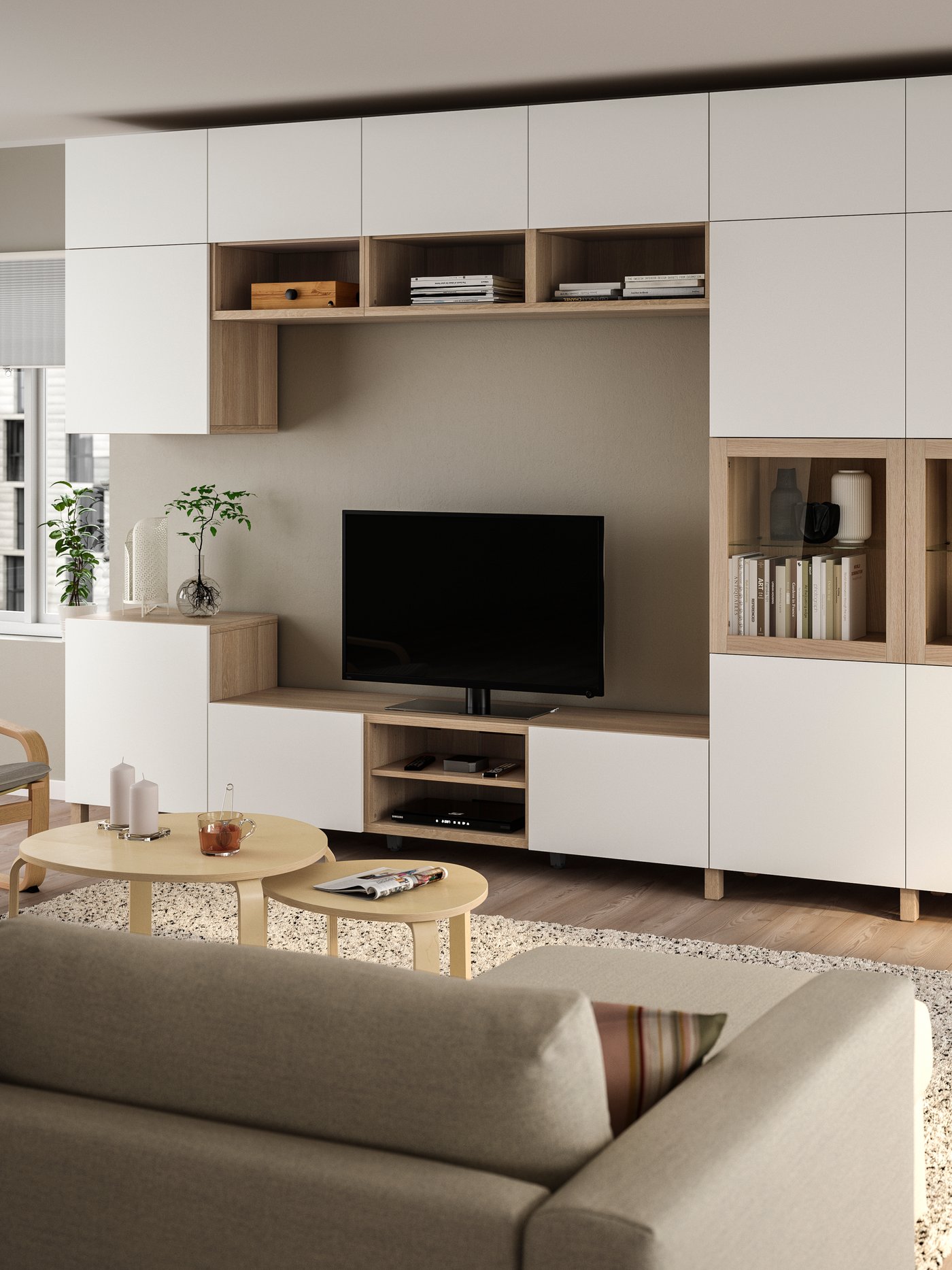 Eine weiß gebeizte Eichenfurnier Lappviken/Sindvik Klarglas BESTÅ TV-Aufbewahrungskombination/Glastüren im Wohnzimmer.