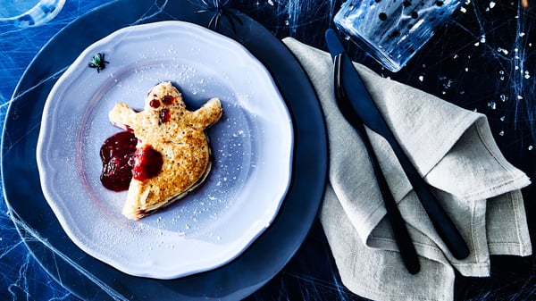 Ett Halloweenspöke i form av en pannkaka ligger på en UPPLAGA assiett.