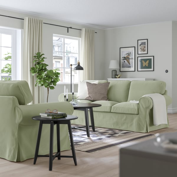 Ein EKTORP 3er Sofa mit hellgrünem Bezug steht in einem Wohnzimmer. 