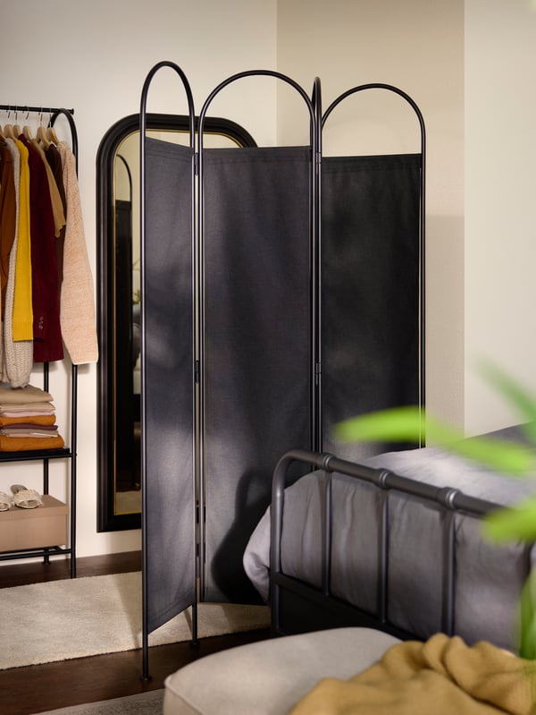 GRÅFJÄLLET room divider, standing between bed and dressing area with mirror and GRÅFJÄLLET clothes rack with shoe storage.