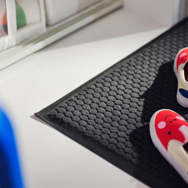 A dark grey VATTENVERK door mat, indoor