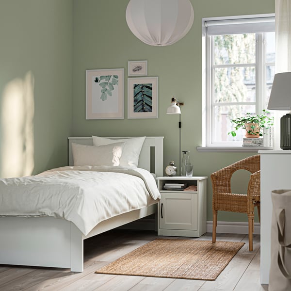 A white SONGESAND bed frame in the bedroom