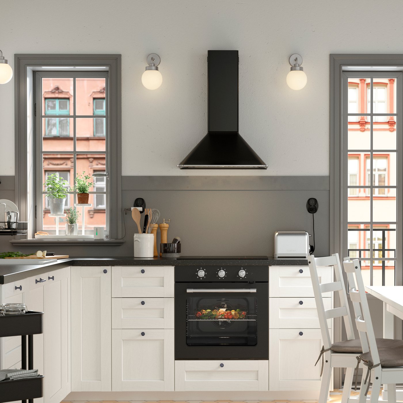 Una cucina bianca e nera in stile tradizionale con frontali bianchi ENKÖPING, un tavolo da pranzo NORDVIKEN bianco circondato da tre sedie e da una panca in pino.