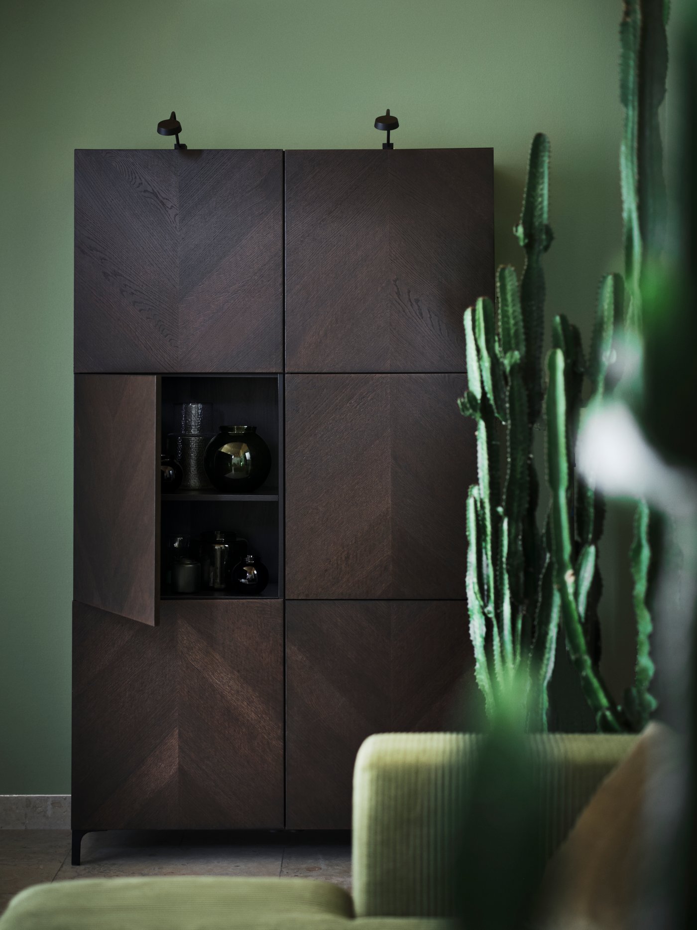 A living room storage combination with doors BESTÅ/HEDEVIKEN with copper veined brown doors a green wall