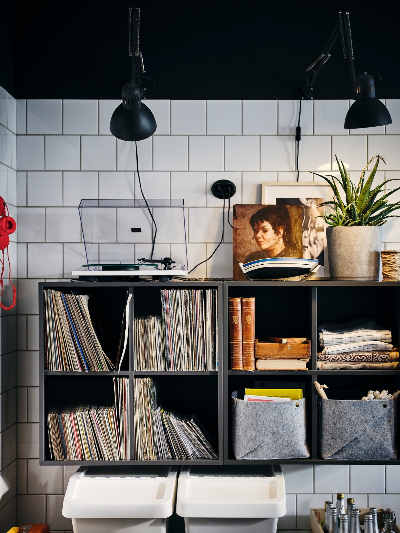 ركن من مطبخ أبيض به مصابيح وخزائن EKET رمادي داكن مثبتة جنبًا إلى جنب على الحائط.