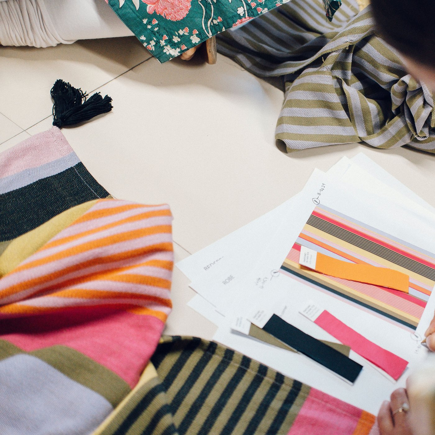 Auf einem weißen Hintergrund liegen viele bunte Stoffe.