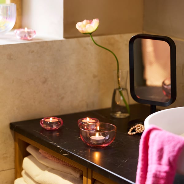 A pink/brown TALLTITA tealight holder in the bathroom