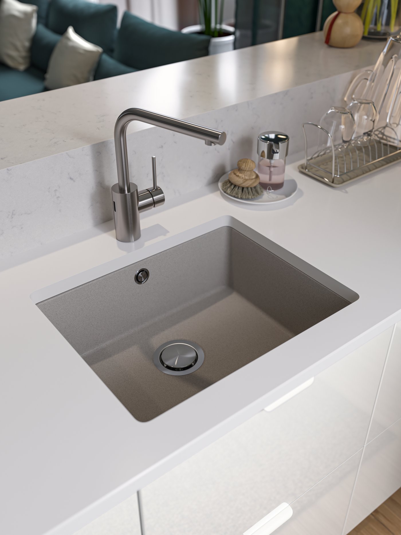 Vista de un lavaplatos metálico empotrado en una cubierta de cerámica blanca en una isla de cocina con muebles del mismo color. 