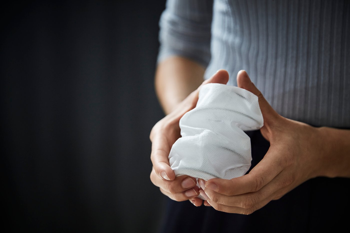 Two hands pressing a mattress spring
