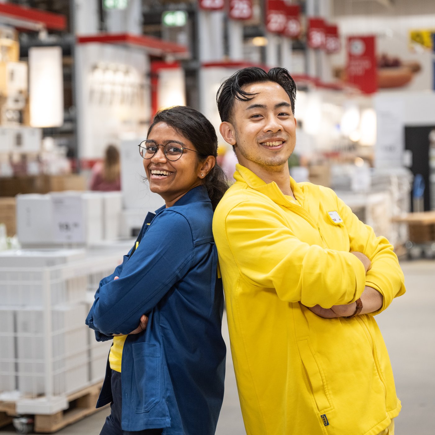 Kaksi IKEA-työntekijää seisovat tavaratalon varastossa selät vastakkain.