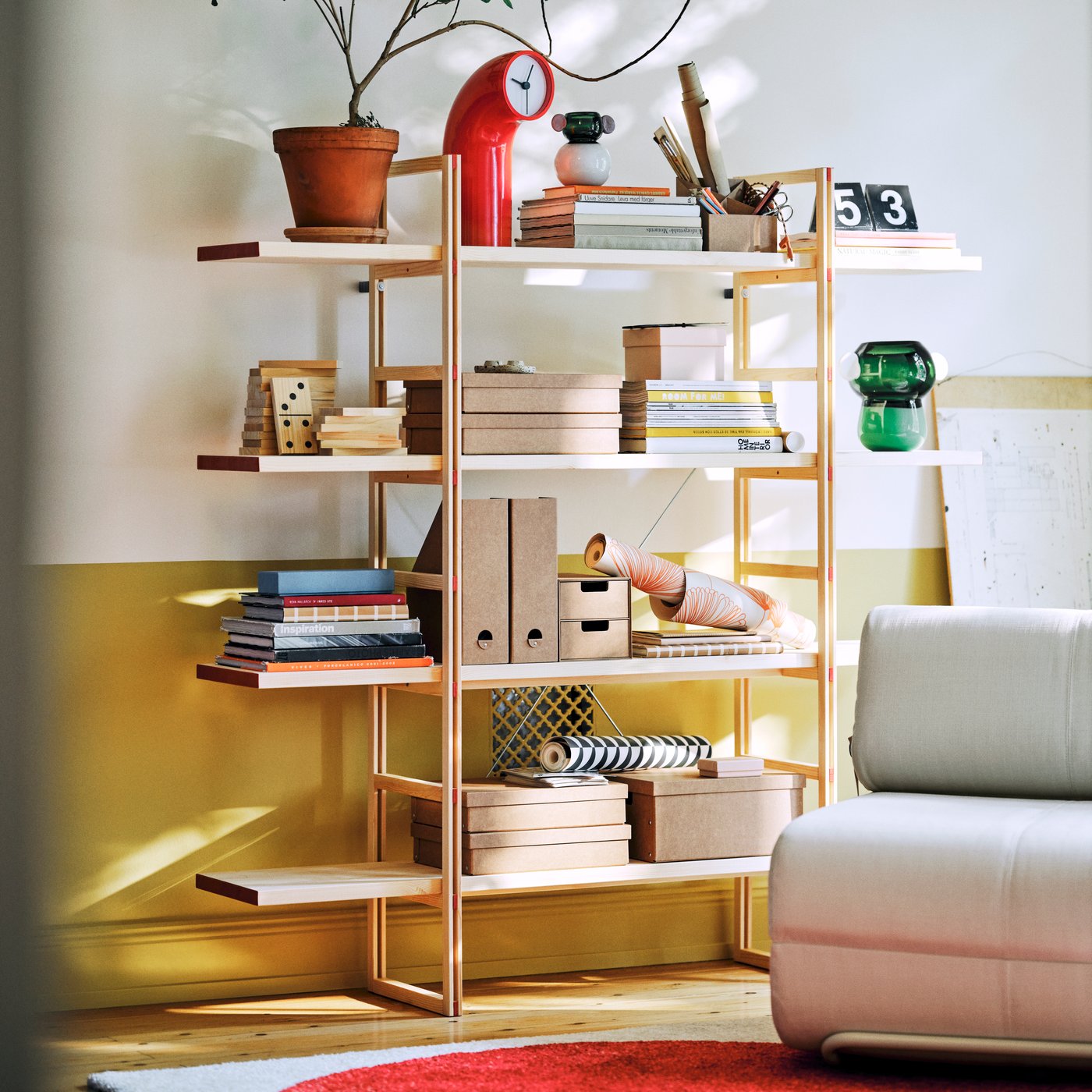 A solid pine IKEA PS 2026 shelving unit displays and stores homefurnishing items in a living room.