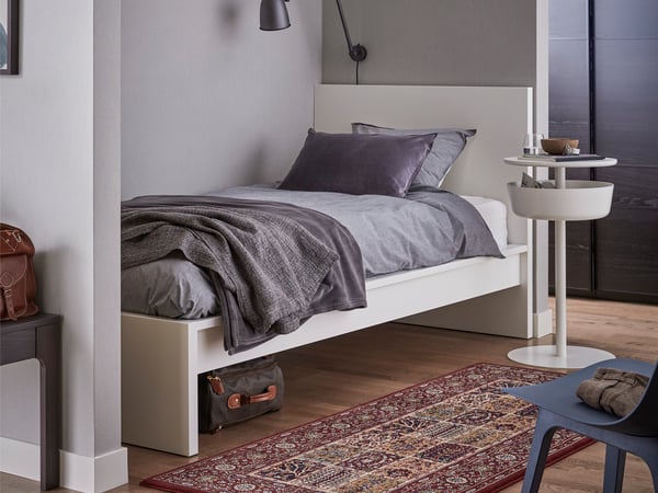 A white MALM bed frame, high in the bedroom.