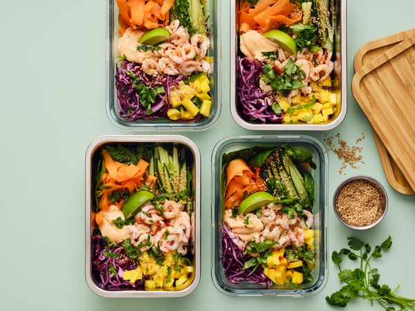 Four containers filled with shrimp and vegetables and mayo.