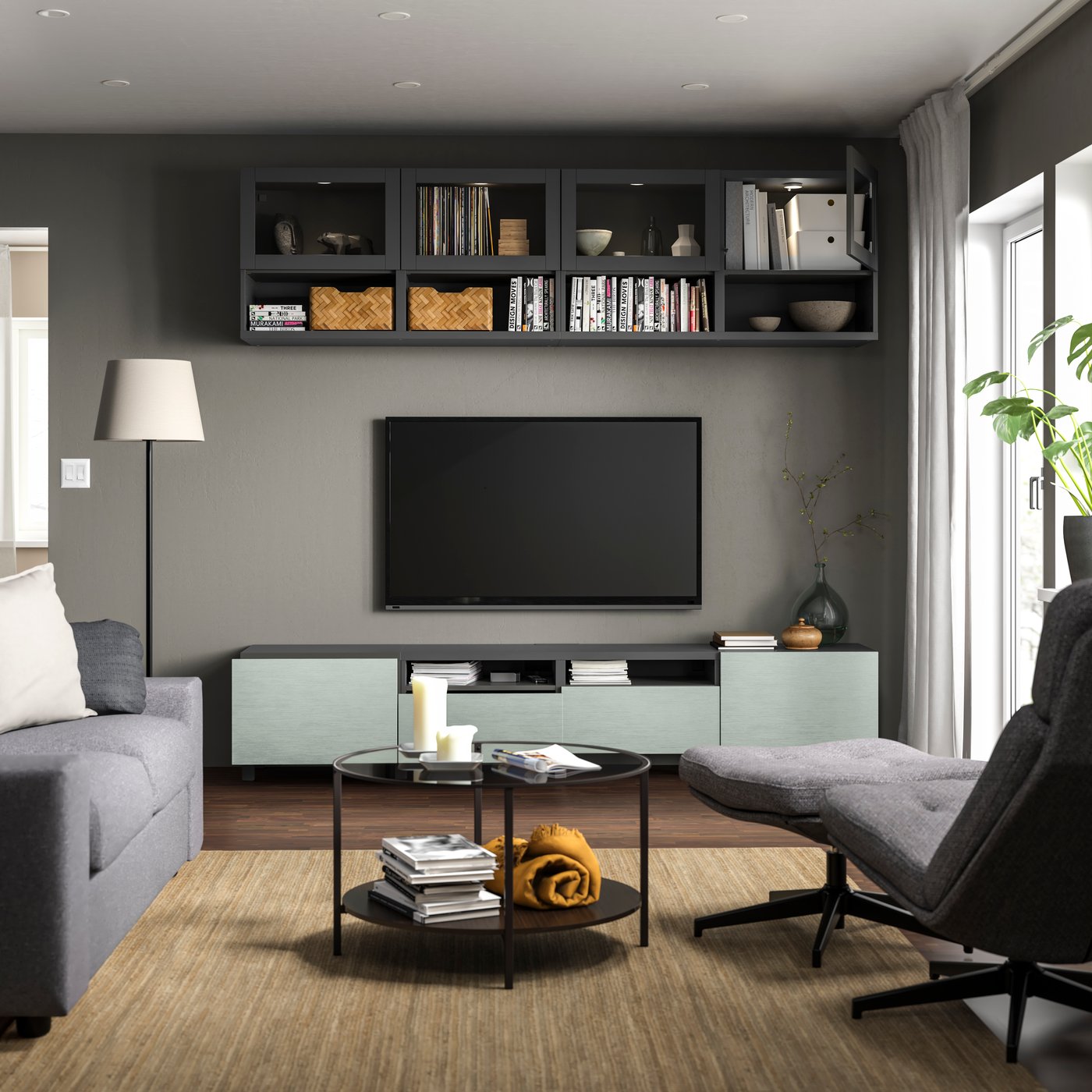 A dark grey Sindvik/Hjortviken/Stubbarp pale grey-green BESTÅ TV storage combination in the living room