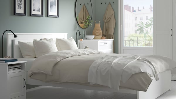 Una camera da letto con mobili bianchi della linea SONGESAND
