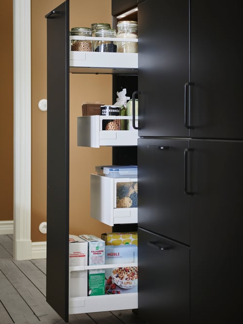 A modern kitchen that features a high cabinet drawer with a black handle and an assembly kit for pull-out function.
