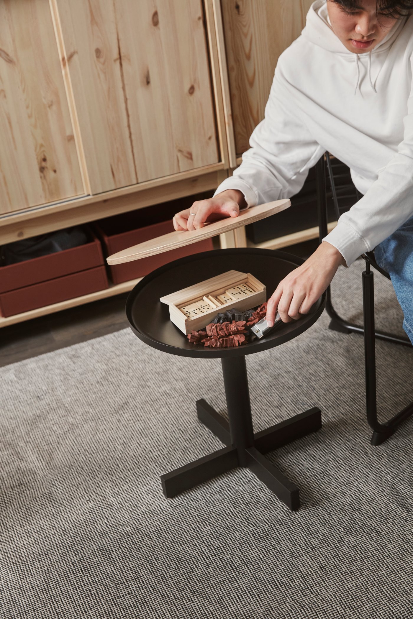 A black GRIMSARBO side table with storage under the lid.
