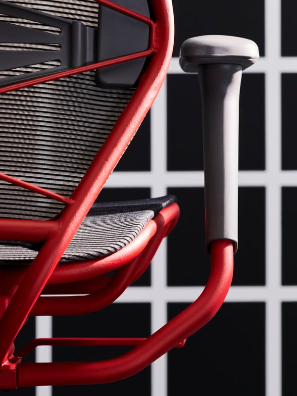 Parts of the back, seat and armrest of a STYRSPEL gaming chair in grey and red against a black and white grid.