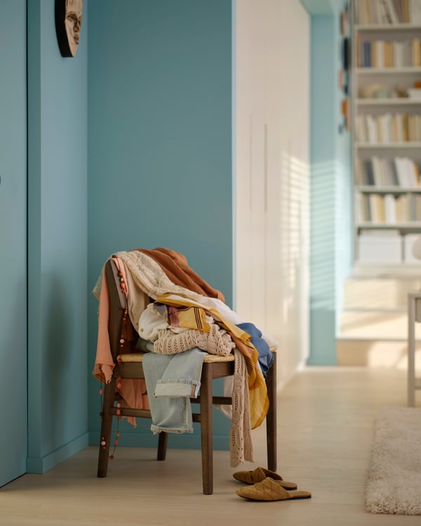 Un fauteuil de chambre avec du linge posé dessus.