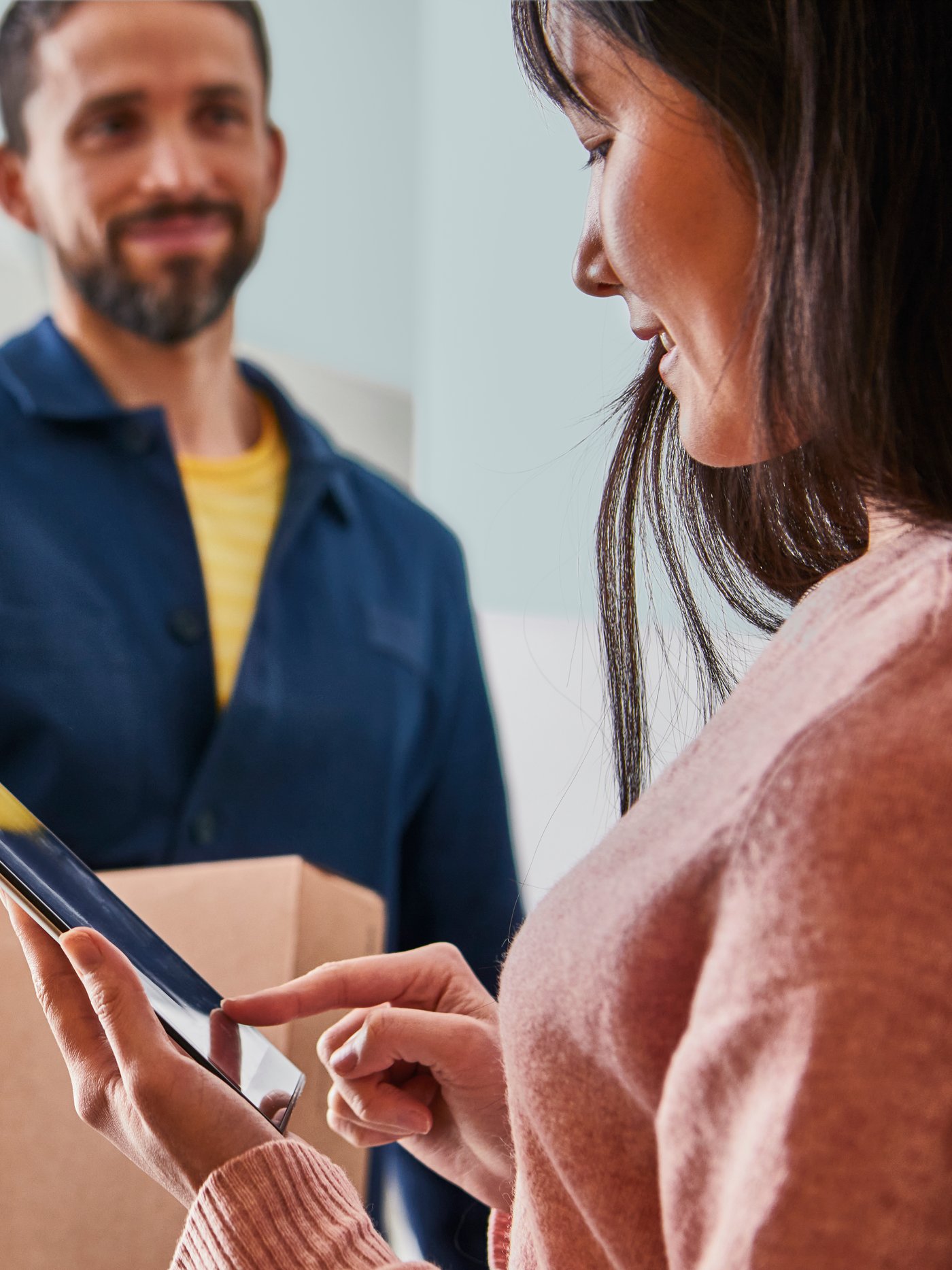 Osoba preuzima pošiljku od dostavljača.