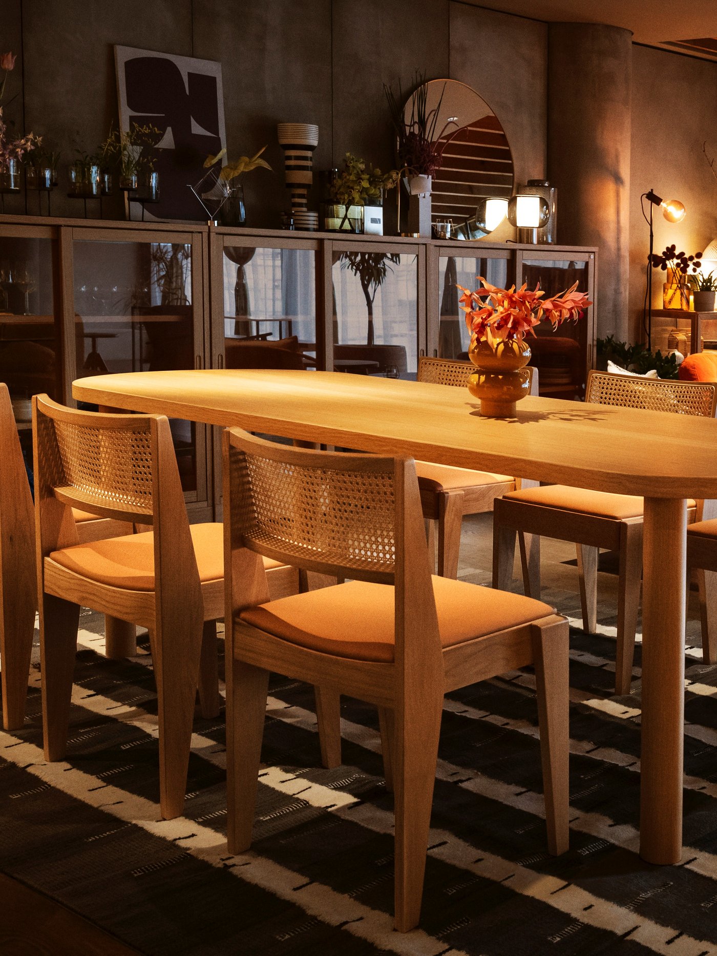 あたたかな照明に照らされたダイニングテーブルとチェアが並び、キャビネットや花でコーディネートされたイケアのリビングダイニング