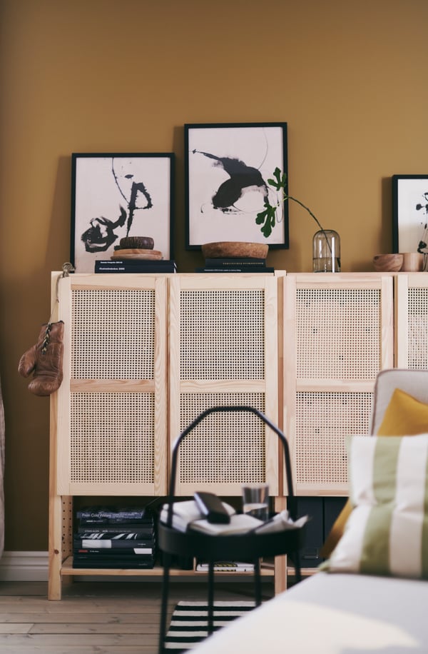 V obytnom priestore v pastelových farbách vidno skrinky IVAR a čierny príručný stolík BURVIK.