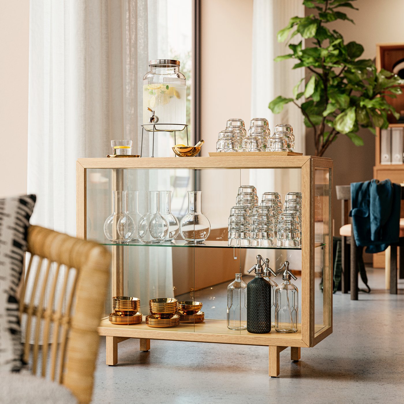 A natural oak veneer STOCKHOLM 2025 glass-door cabinet in a hotel lobby that creates a drink station with refreshments.