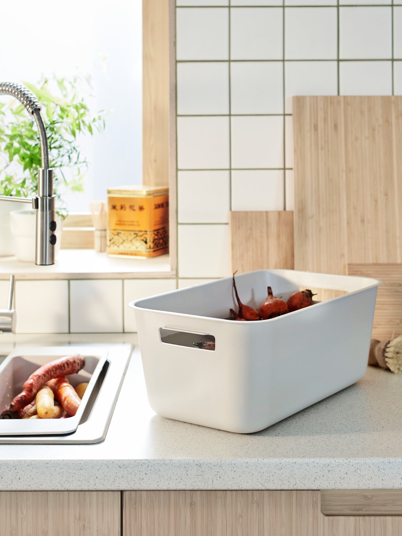 A kitchen top with grey GRUNDVATTNET washing-up bowl and GRUNDVATTNET colander used for rinsing vegetables.