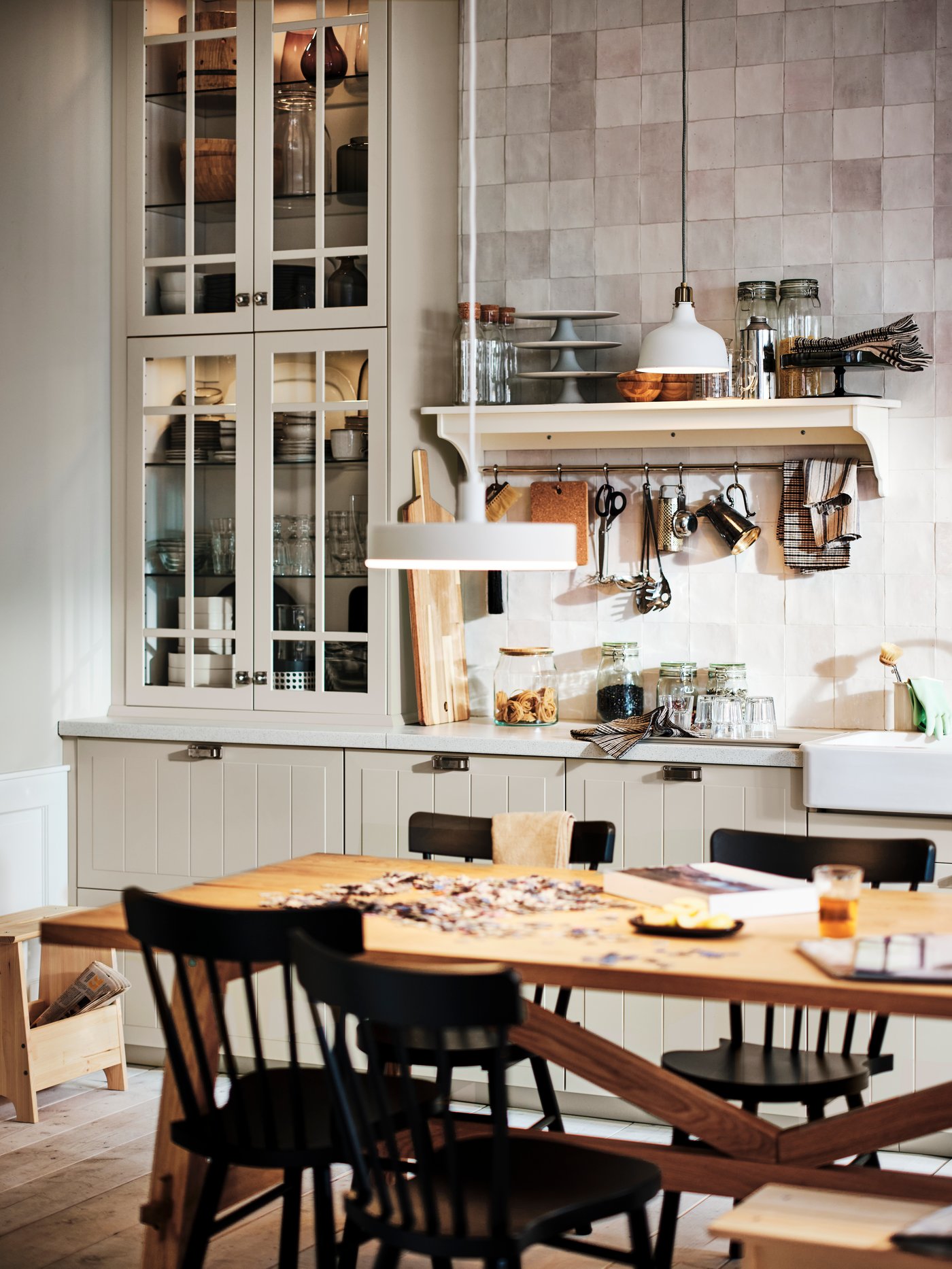 Eine Wohnküche im Landhausstil von IKEA mit beigen STENSUND Fronten, einem MÖCKELBY Tisch und NORRARYD Stühlen.