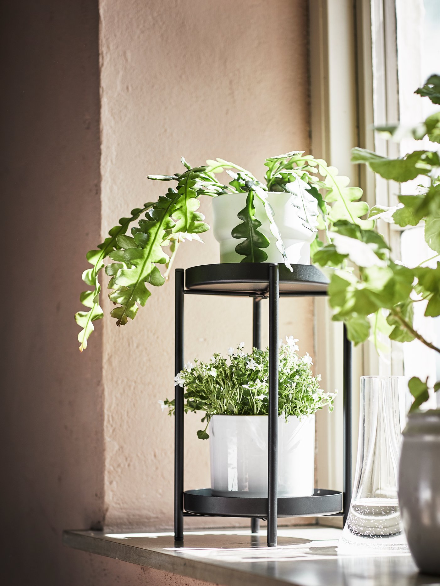 Soporte de planta OLIVBLAD en espacio interior del hogar. Con acabado en tono negro. 