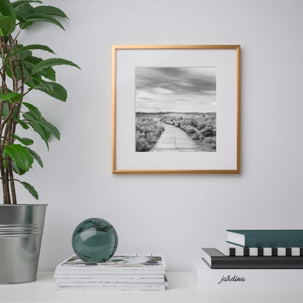 An IKEA LOMVIKEN gold-colour square frame in the living room. 