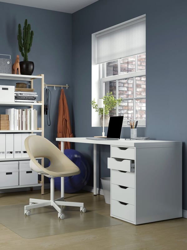 A colourful room with a workspace flanked by two blue HELMER drawer units on castors and a NILSERIK standing support.