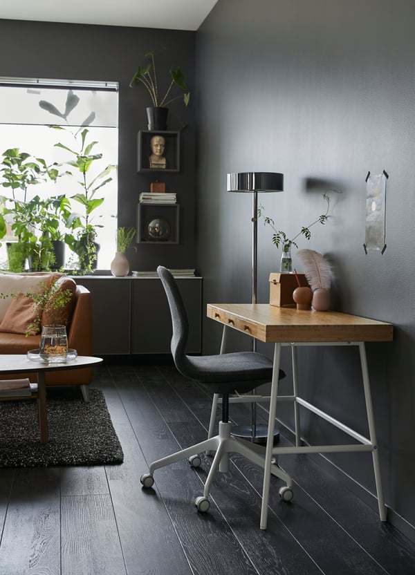 Un living con plantas y en una de sus esquinas  un escritorio LILLÅSEN con silla de escritorio LÅNGFJÄLL.