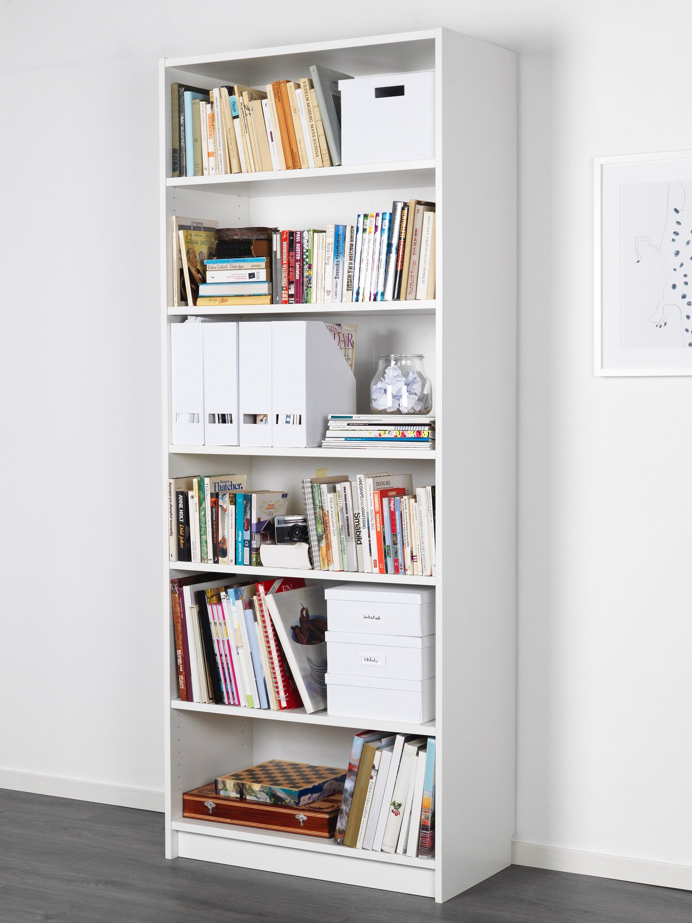 Ein weißes BILLY Bücherregal, 80 breit, 40 tief und 202 hoch, steht vor einer weißen Wand.