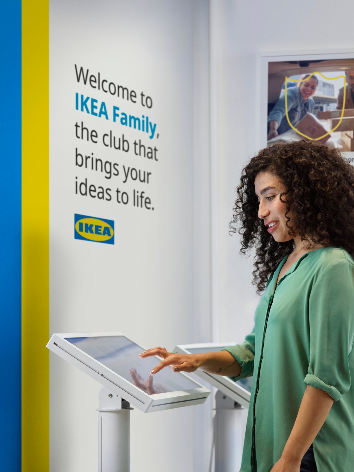 Vihreäpaitainen nainen liittyy IKEA Family -jäseneksi tavaratalon päätteellä. 