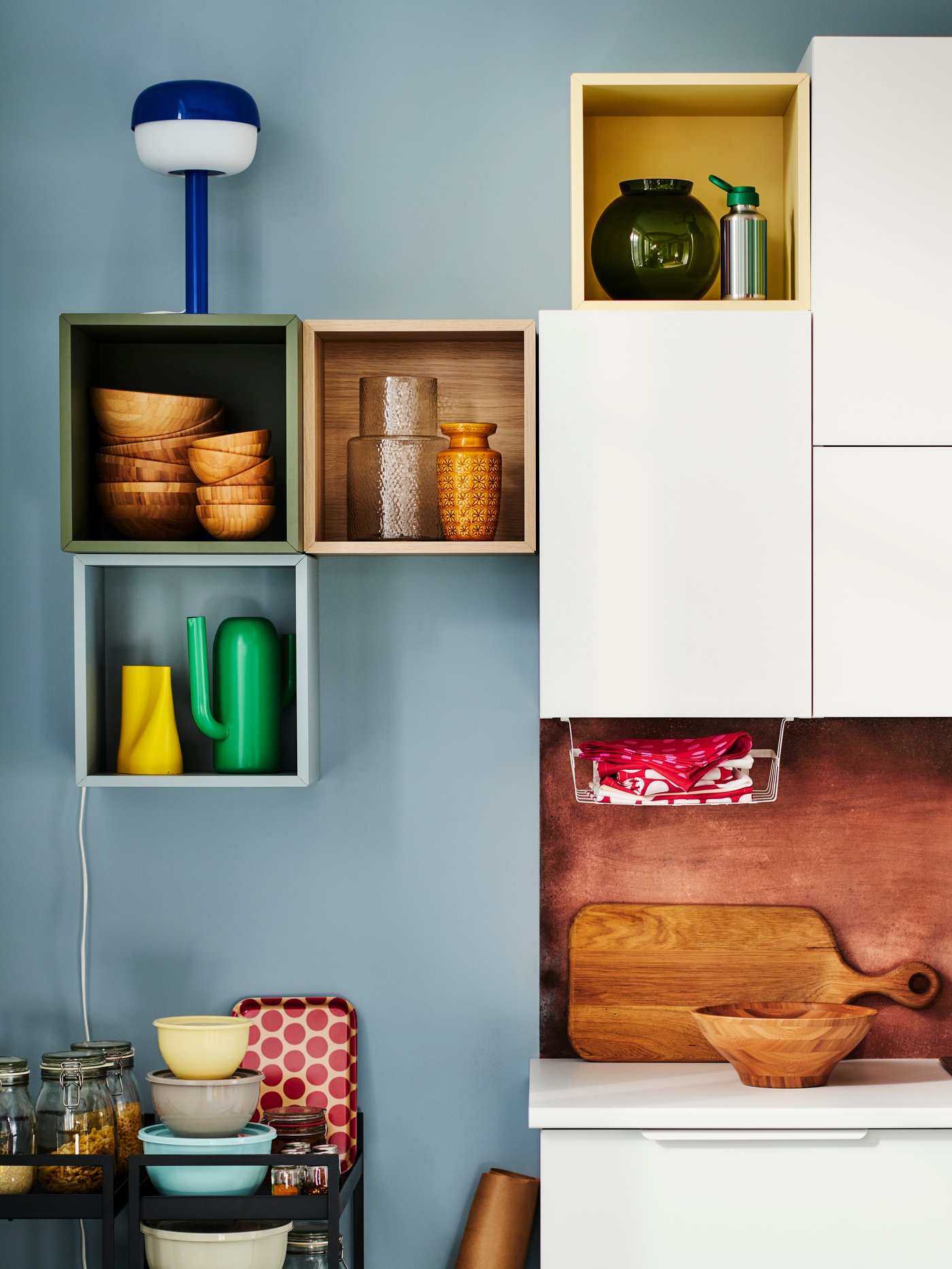 Cubes astucieux EKET de couleur marron, vert, rose et jaune exposant des objets de décoration.