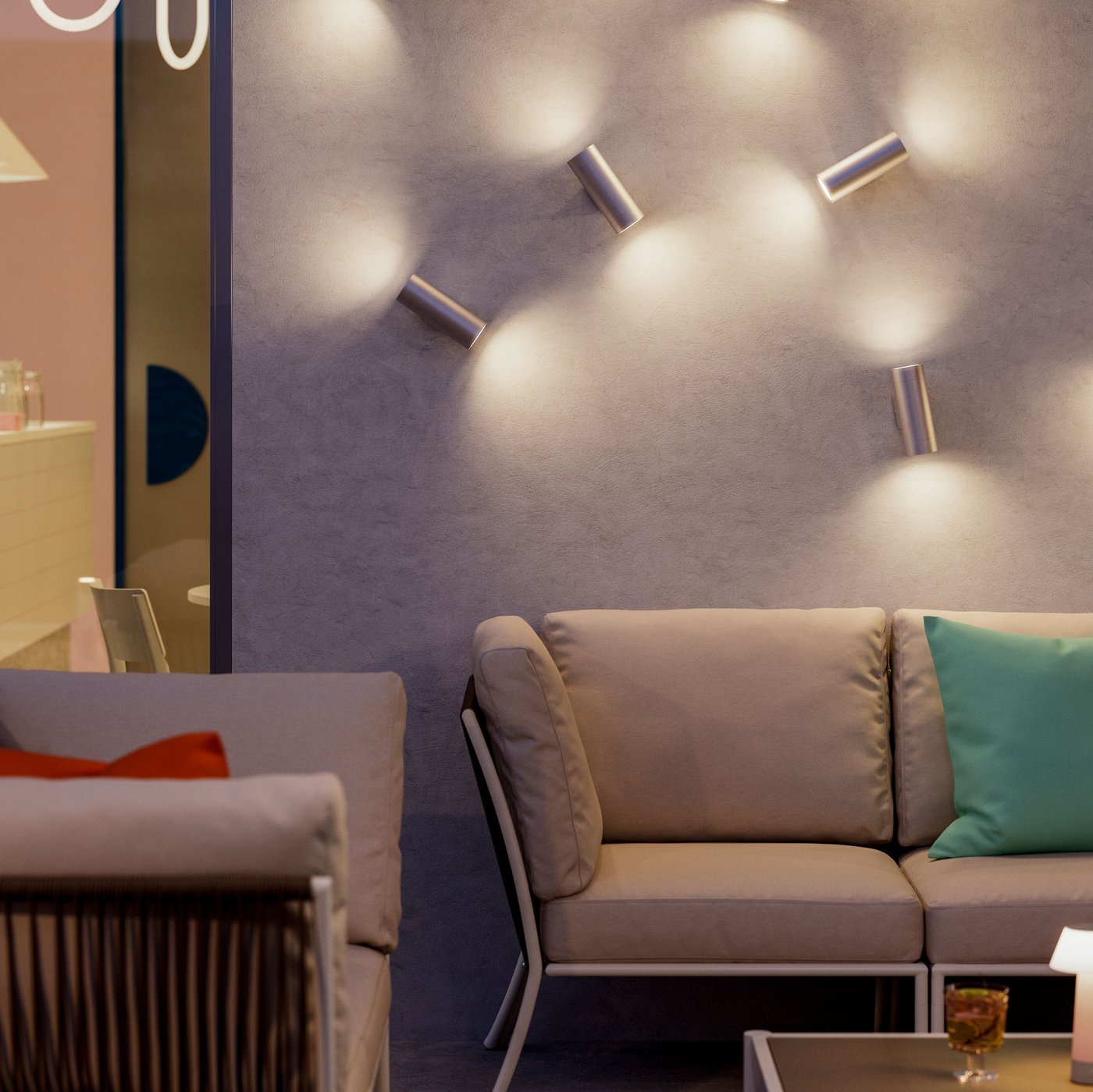 An outdoor evening café lounging area with SEGERÖN outdoor conversation sets under GRÖNSPRÖT wall up/down outdoor lighting.