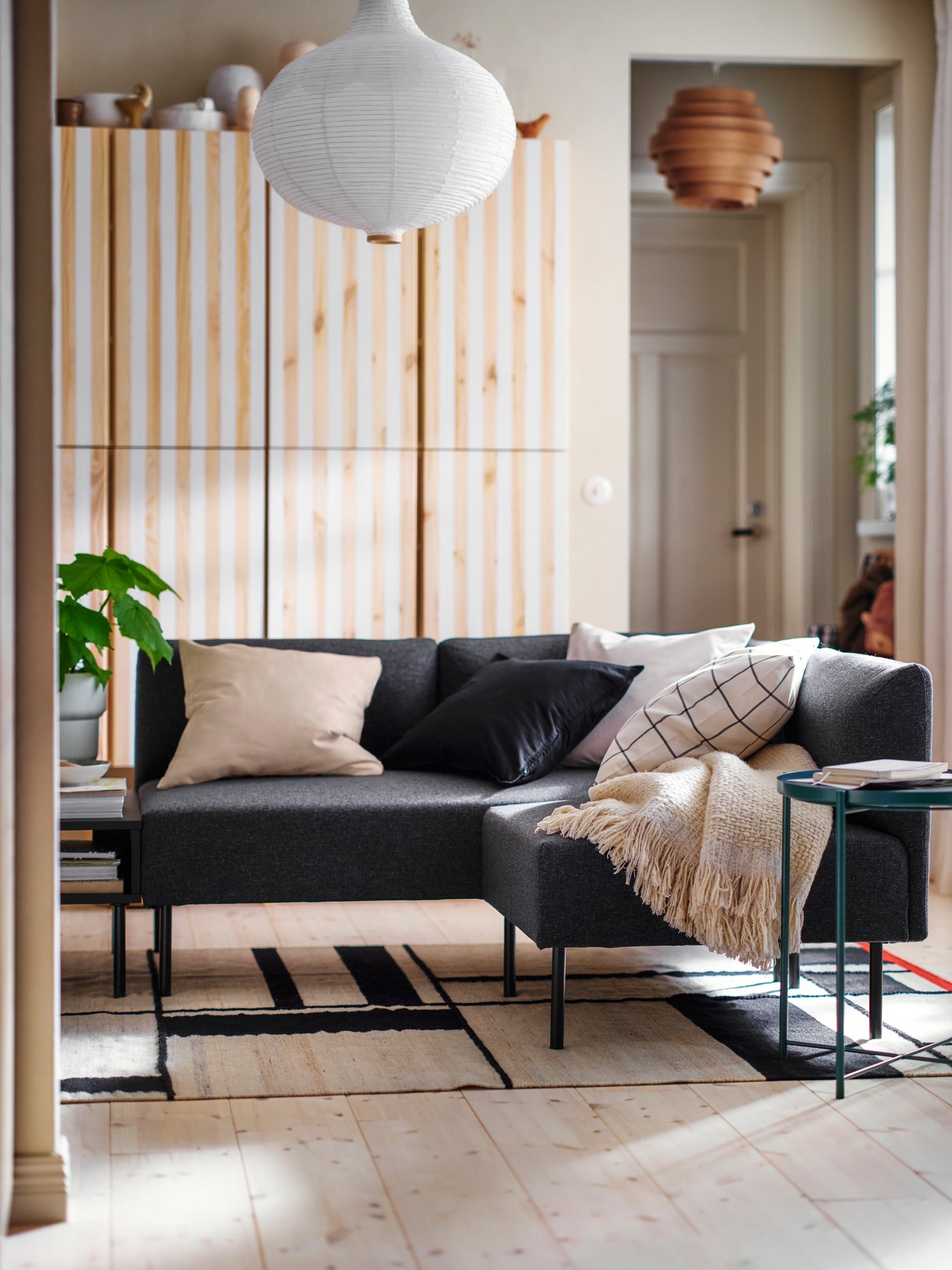 A dark grey LILLEHEM sofa in a bright living room with a light wooden floor.