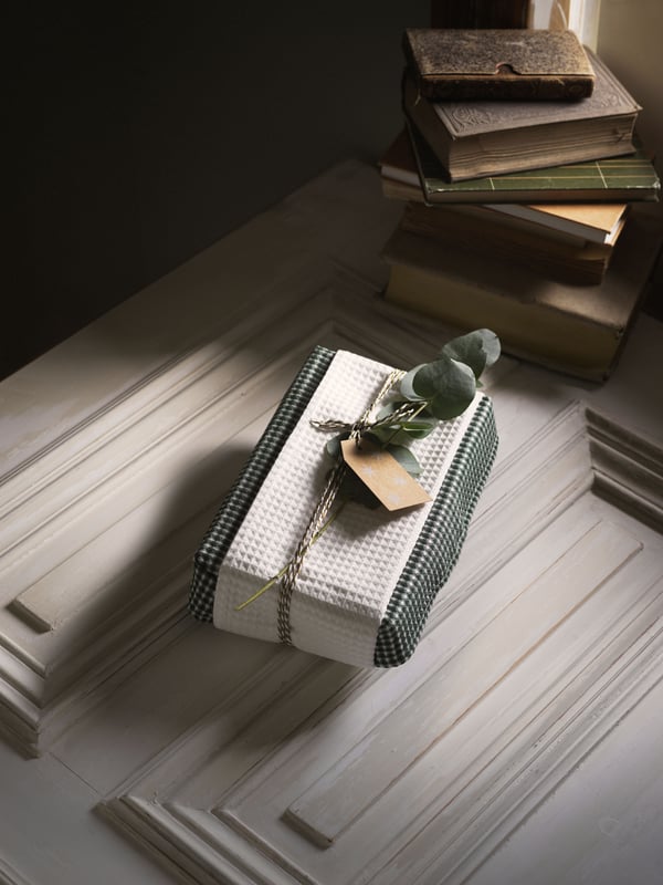 R: A stack of books, a wrapped gift, and a cup of coffee on a wooden table, labeled “Remember to surprise him with a gift”