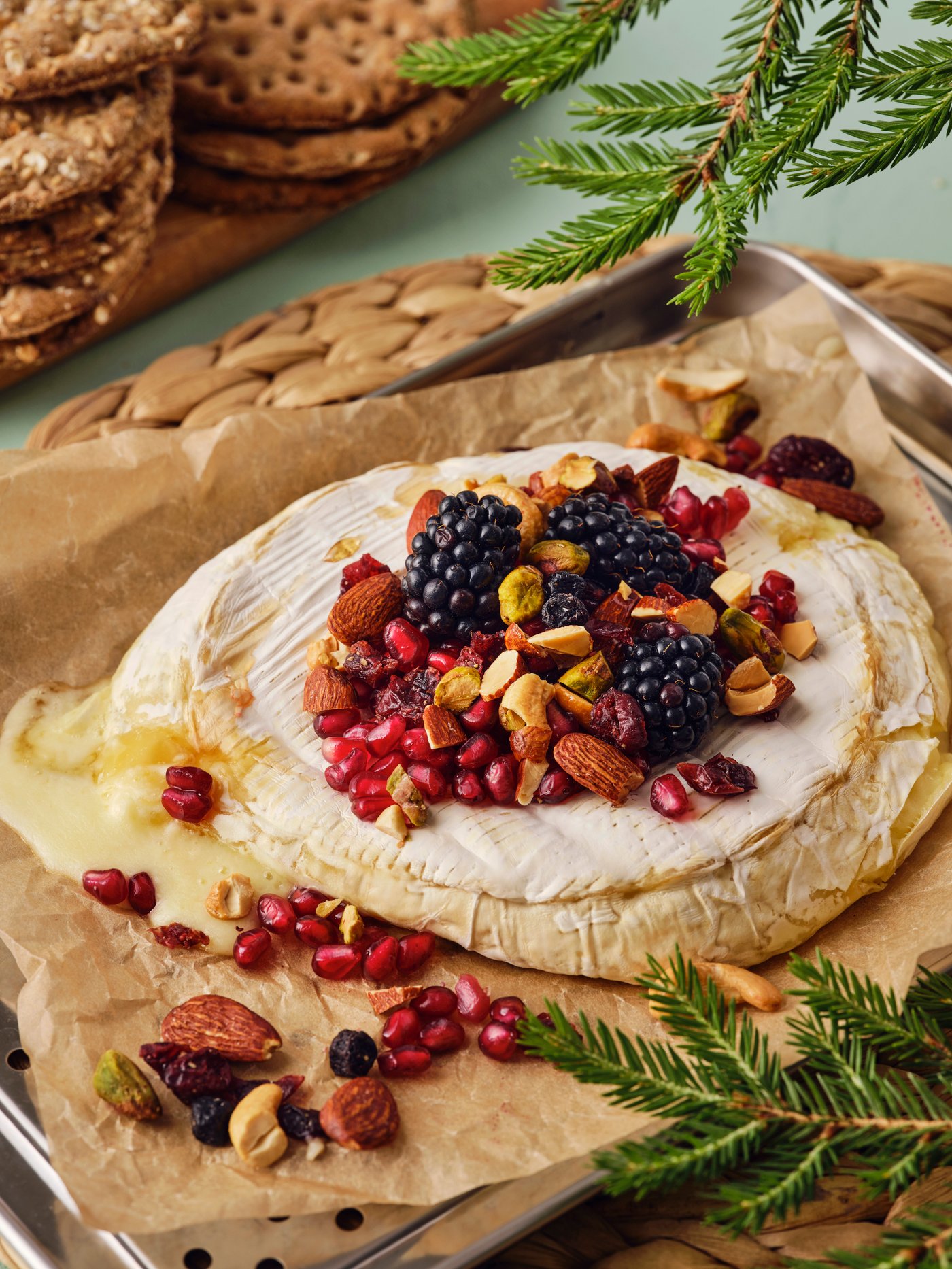 Una teglia con del brie al forno con frutti di bosco e noci tostate