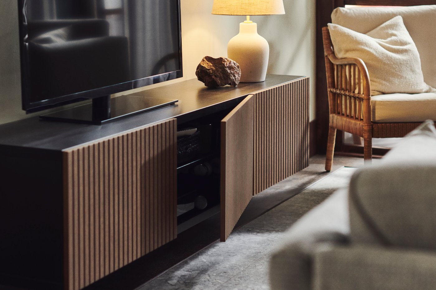 A BESTÅ TV unit with dark‑brown doors and a beige BLIDVÄDER table lamp in the living room