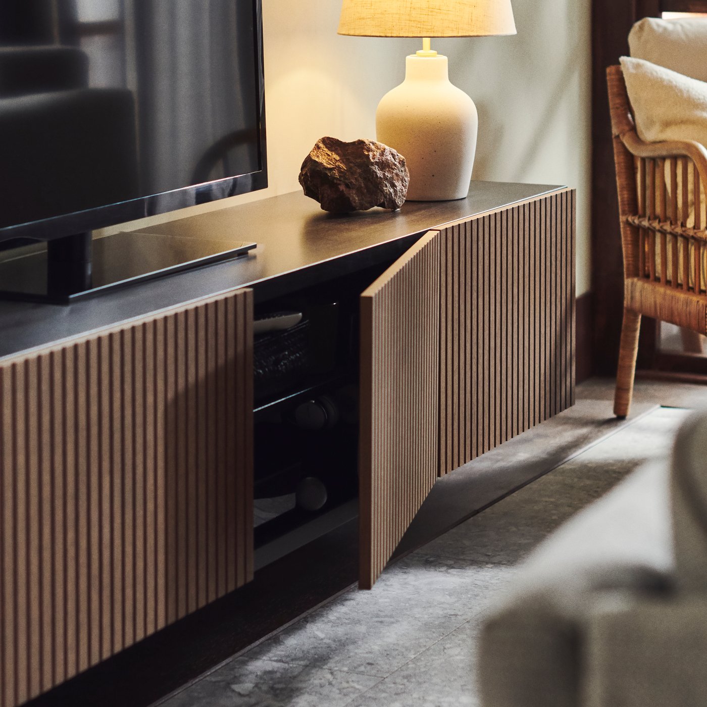 En brunsvart BESTÅ tv-benk med valnøtt-dører.