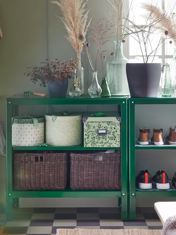 KOLBJÖRN shelving units with FJÄLLA storage boxes, GABBIG baskets and shoes on shelves, and plant pots and vases on top.