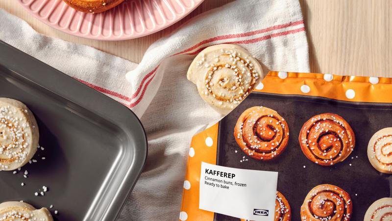 KAFFEREP-kanelipulla pakasteita keittiönpöydällä ja uunipellillä, valmiina paistettavaksi.