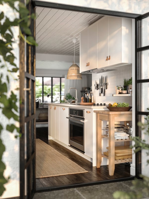 A kitchen with white fronts, an oven and white wall cabinets.