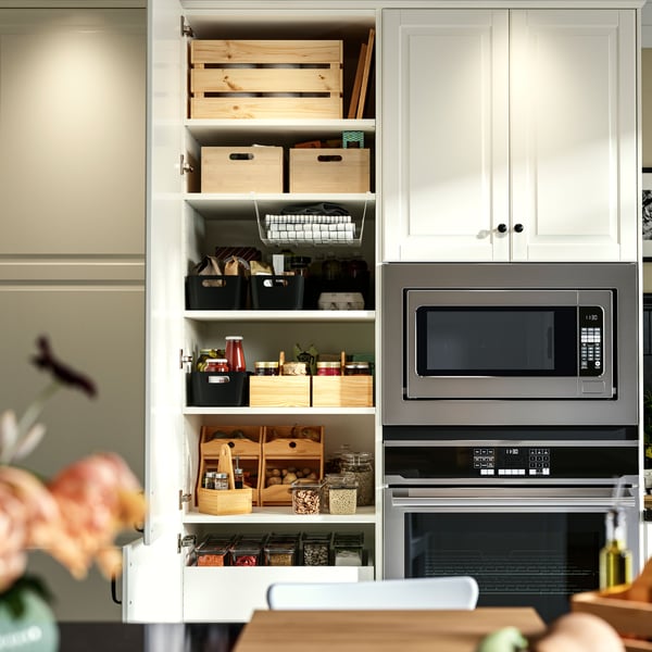 Eine moderne Küche mit einem Backofen und einer Mikrowelle aus Edelstahl sowie einem übersichtlichen Schrank mit UPPDATERA-Aufbewahrungsboxen.