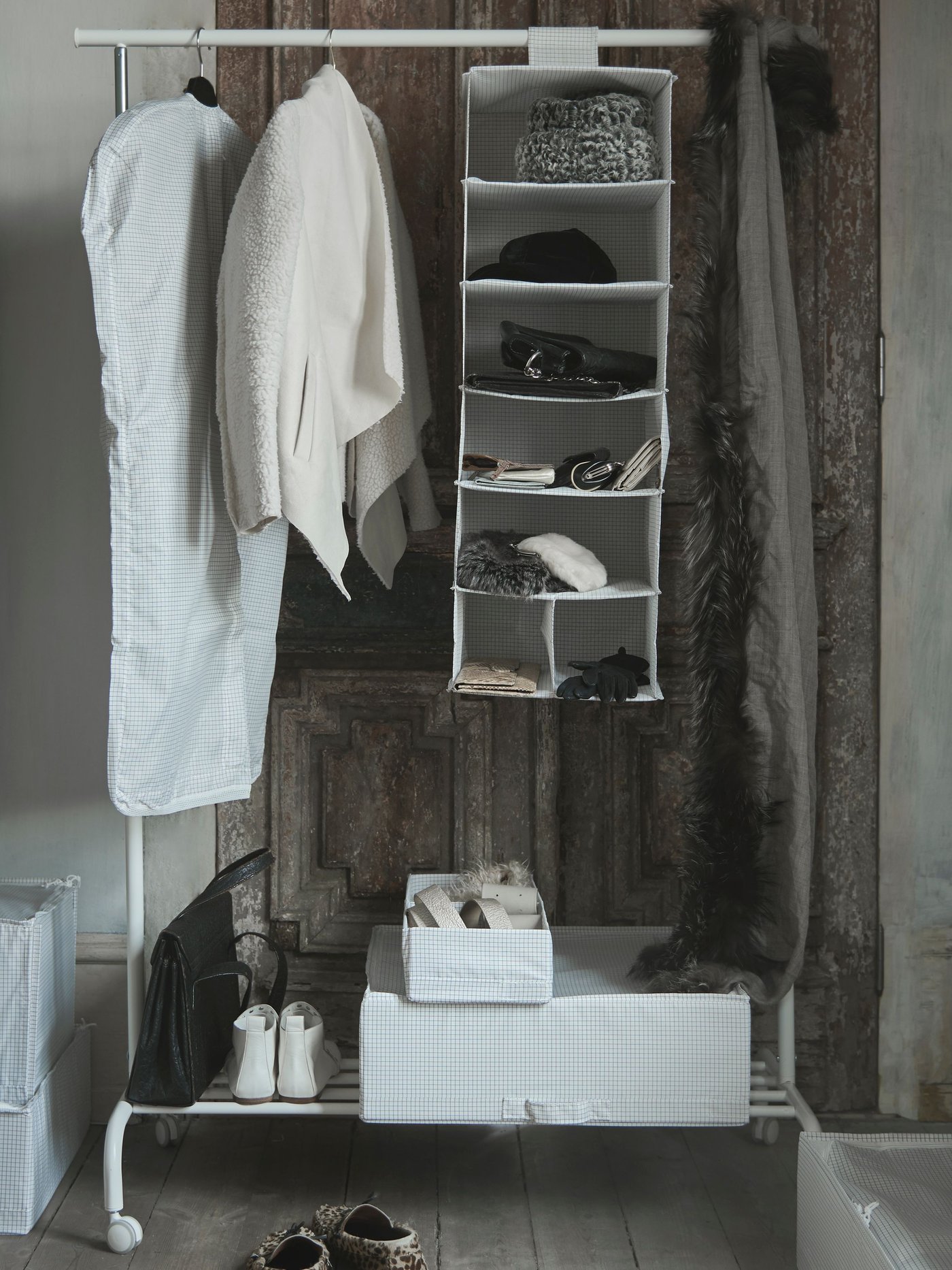 Unha funda de roupa STUK branca/gris no corredor 